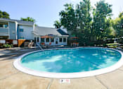 Thumbnail 3 of 19 - View of community pool, lush shrubbery, private patio/ balcony and exterior of buildings