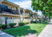 Thumbnail 24 of 33 - a row of apartments with balconies and green grass and trees