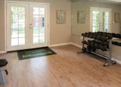 Thumbnail 30 of 33 - a fitness room with weights and a yoga mat on the hardwood floor