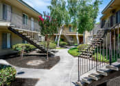 Thumbnail 27 of 33 - a courtyard with stairs and trees in front of an apartment building