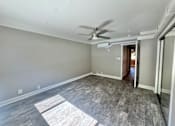 Thumbnail 11 of 28 - A room with a ceiling fan and light fixture, and a doorway leading to another room.