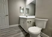 Thumbnail 5 of 28 - A white toilet sits next to a sink in a bathroom.