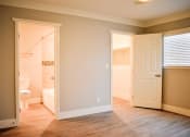 Thumbnail 8 of 16 - View of bedroom with wood-like flooring with a view into the connecting bathroom and a view into the walk in closet