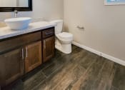 Thumbnail 4 of 54 - View of bathroom vanity with vessel sink, large mirror, toilet, and well lit window.