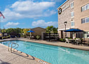 Thumbnail 3 of 65 - our apartments have a swimming pool and outdoor furniture  at Parks Residential - Richardson, Texas