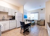 Thumbnail 11 of 65 - a kitchen and living room with white appliances and wood floors at Parks Residential - Richardson, Richardson, Texas