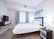 Thumbnail 21 of 65 - a bedroom with a large bed and a tv at Parks Residential - Richardson, Richardson, Texas