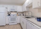 Thumbnail 28 of 65 - a white kitchen with white appliances and white cabinets at Parks Residential - Richardson, Richardson, Texas