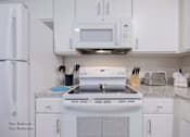 Thumbnail 29 of 65 - a kitchen with white appliances and white cabinets at Parks Residential - Richardson, Richardson, 75082