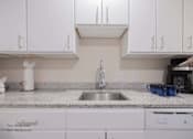 Thumbnail 30 of 65 - a kitchen counter with a sink and white cabinets at Parks Residential - Richardson, Texas, 75082