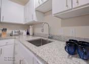 Thumbnail 31 of 65 - a kitchen with granite counter tops and a sink at Parks Residential - Richardson, Richardson, 75082