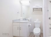 Thumbnail 40 of 65 - a bathroom with a toilet and a sink and a mirror at Parks Residential - Richardson, Richardson, Texas