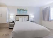 Thumbnail 32 of 65 - a bedroom with a bed and two nightstands and a window  at Parks Residential - Richardson, Texas
