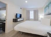 Thumbnail 33 of 65 - a bedroom with a bed and a tv in a hotel room at Parks Residential - Richardson, Richardson, 75082