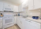 Thumbnail 49 of 65 - a white kitchen with white appliances and white cabinets at Parks Residential - Richardson, Texas