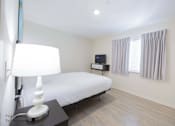 Thumbnail 59 of 65 - a bedroom with a bed and a lamp and a window at Parks Residential - Richardson, Richardson, Texas