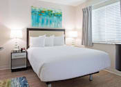 Thumbnail 10 of 12 - a bedroom with a white bed and a painting on the wall at Parks Residential - Denver, Colorado, 80111