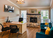 Thumbnail 20 of 20 - A room with a stone fireplace and a green couch.