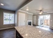Thumbnail 3 of 16 - View from kitchen bar top into living room with fireplace and access to private balcony/patio through sliding glass door, with well lit window