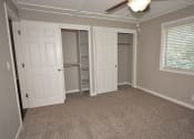 Thumbnail 11 of 27 - View of bedroom with carpet flooring, sliding door closet with built in shelving, well lit window and ceiling fan