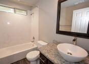 Thumbnail 13 of 27 - view of bathroom with vessel sink, mirror, toilet, tub shower combo, and well lit window