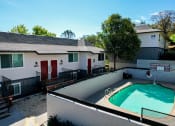 Thumbnail 5 of 27 - Exterior view of a building and gated community pool at Persimmon Terrace