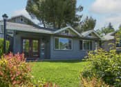 Thumbnail 1 of 17 - a blue building with a lawn in front of it