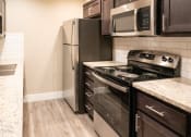 Thumbnail 7 of 17 - an updated kitchen with stainless steel appliances and wood flooring