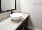 Thumbnail 12 of 17 - a bathroom with a bowl sink on a counter and a mirror