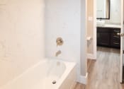 Thumbnail 13 of 17 - a bathroom with a tub and a sink and a mirror