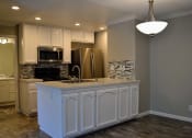 Thumbnail 11 of 25 - View of kitchen with recessed lighting, stainless appliances, tile backsplash and white cabinets