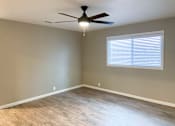 Thumbnail 2 of 12 - living room with wood look flooring, ceiling fan, and well lit window