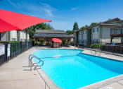 Thumbnail 31 of 34 - View of gated community pool with seating under umbrellas and covered area with picnic table and seating