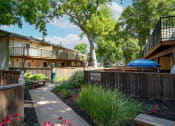 Thumbnail 23 of 34 - View in between buildings showcasing lush landscaping with sidewalk in between buildings and private patio/balcony