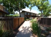 Thumbnail 14 of 34 - View of sidewalk winding between private patio/balcony with blooming landscaping and trees shading the sidewalk