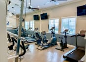 Thumbnail 18 of 19 - a gym with treadmills and other exercise equipment