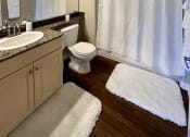 Thumbnail 10 of 19 - a bathroom with a shower and a sink and a toilet