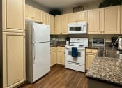 Thumbnail 6 of 19 - a kitchen with white appliances and wooden cabinets