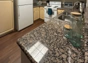 Thumbnail 5 of 19 - a kitchen with white appliances and granite counter tops
