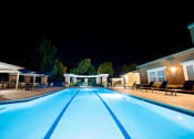 Thumbnail 13 of 19 - a swimming pool at night next to a clubhouse