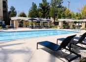 Thumbnail 12 of 19 - a swimming pool with lounge chairs and umbrellas at Vista Pointe