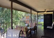 Thumbnail 20 of 23 - a covered porch with chairs and a table