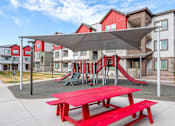Thumbnail 61 of 76 - A playground with a red picnic table and slide.