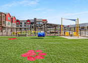 Thumbnail 49 of 76 - A playground with a blue tarp and red flower pattern on the grass.