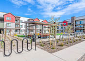 Thumbnail 59 of 76 - A playground area with a slide and a railing in front of apartment buildings.