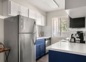 Thumbnail 1 of 48 - a kitchen with white countertops and blue cabinets at Denim Scottsdale, Scottsdale, 85251