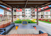 Thumbnail 57 of 76 - A modern outdoor seating area with a concrete table and chairs.