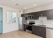 Thumbnail 3 of 22 - A kitchen with a blue door and stainless steel appliances.at The 89 on Hayden, Scottsdale  
