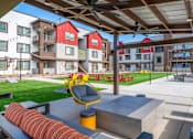 Thumbnail 60 of 76 - A patio area with a yellow chair and a red couch.