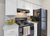 Thumbnail 20 of 36 - a kitchen with black appliances and white cabinets  at Glen Brae, Arizona, 85301